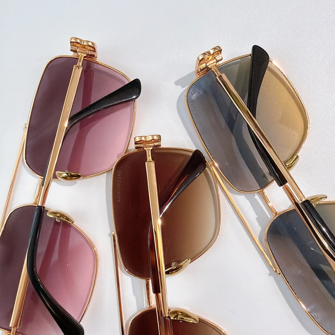Set of gold-framed sunglasses with mixed tinted lenses in purple, brown, and blue