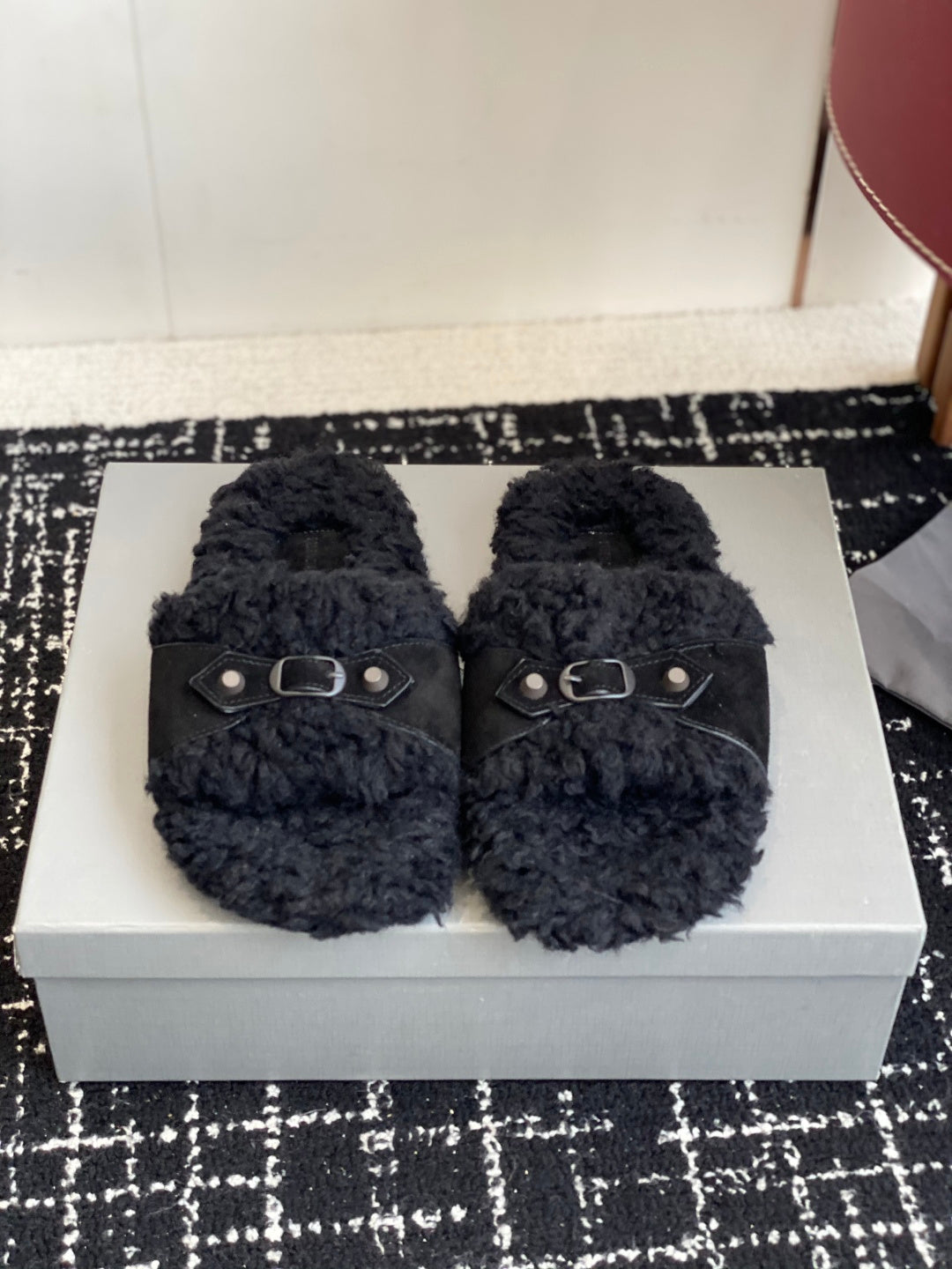 Black fuzzy slide sandals with two silver buckles on dark straps