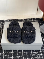 Black fuzzy slide sandals with two silver buckle straps on the upper