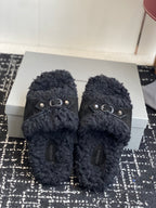 Black fuzzy slide sandals with silver buckle detail on the front straps