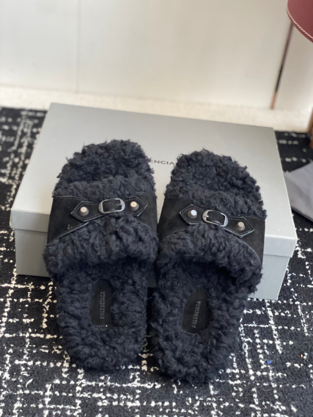 Black fuzzy slide sandals with studded metal buckles, front view