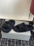 Black fuzzy slide sandals with metal buckle straps, side by side