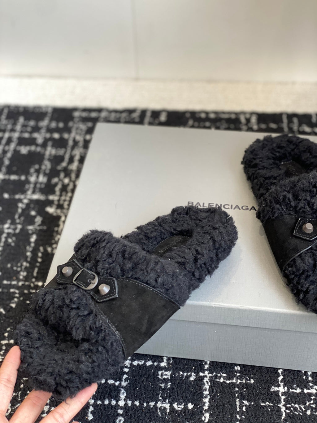 Black fuzzy slide sandals with silver buckle on wide dark strap