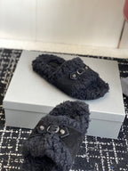 Black fuzzy slide sandals with silver buckle straps and dark upper panel