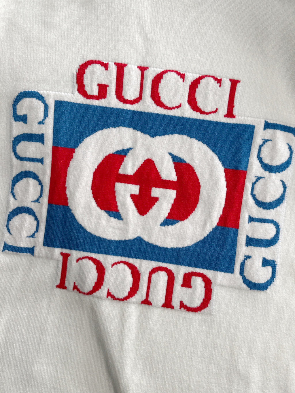 White sweatshirt with red Gucci wordmark and oval logo graphic