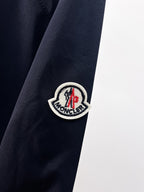 Moncler round crest patch on navy jacket sleeve
