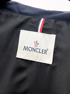 Moncler label tag on navy jacket with red, white and blue stripe