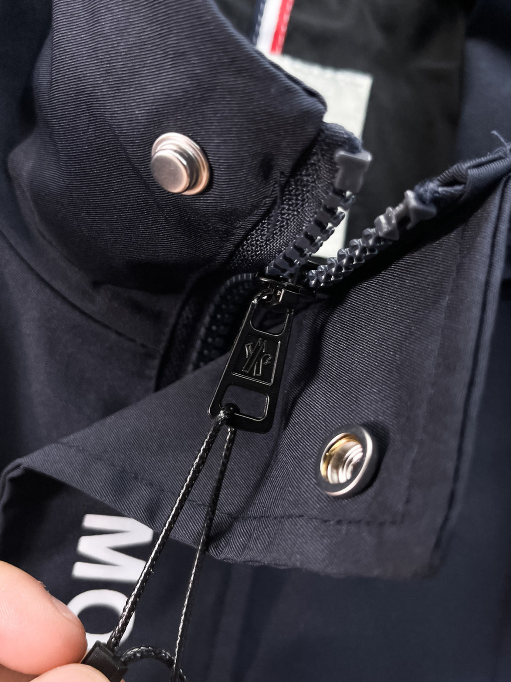 Moncler hooded coat front with zipper, snap buttons, and logo patch