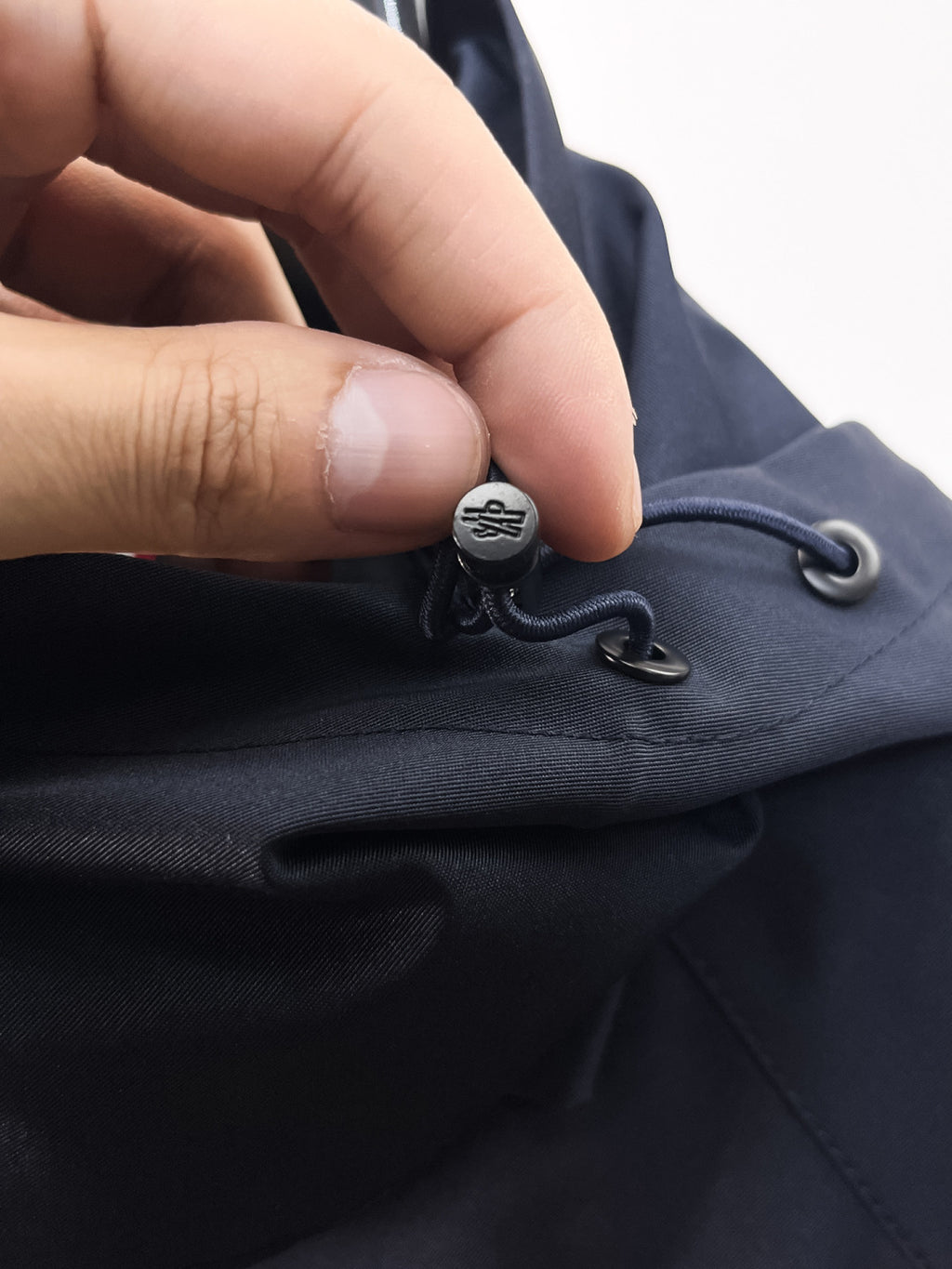 Navy Moncler jacket hem drawcord with metal toggle