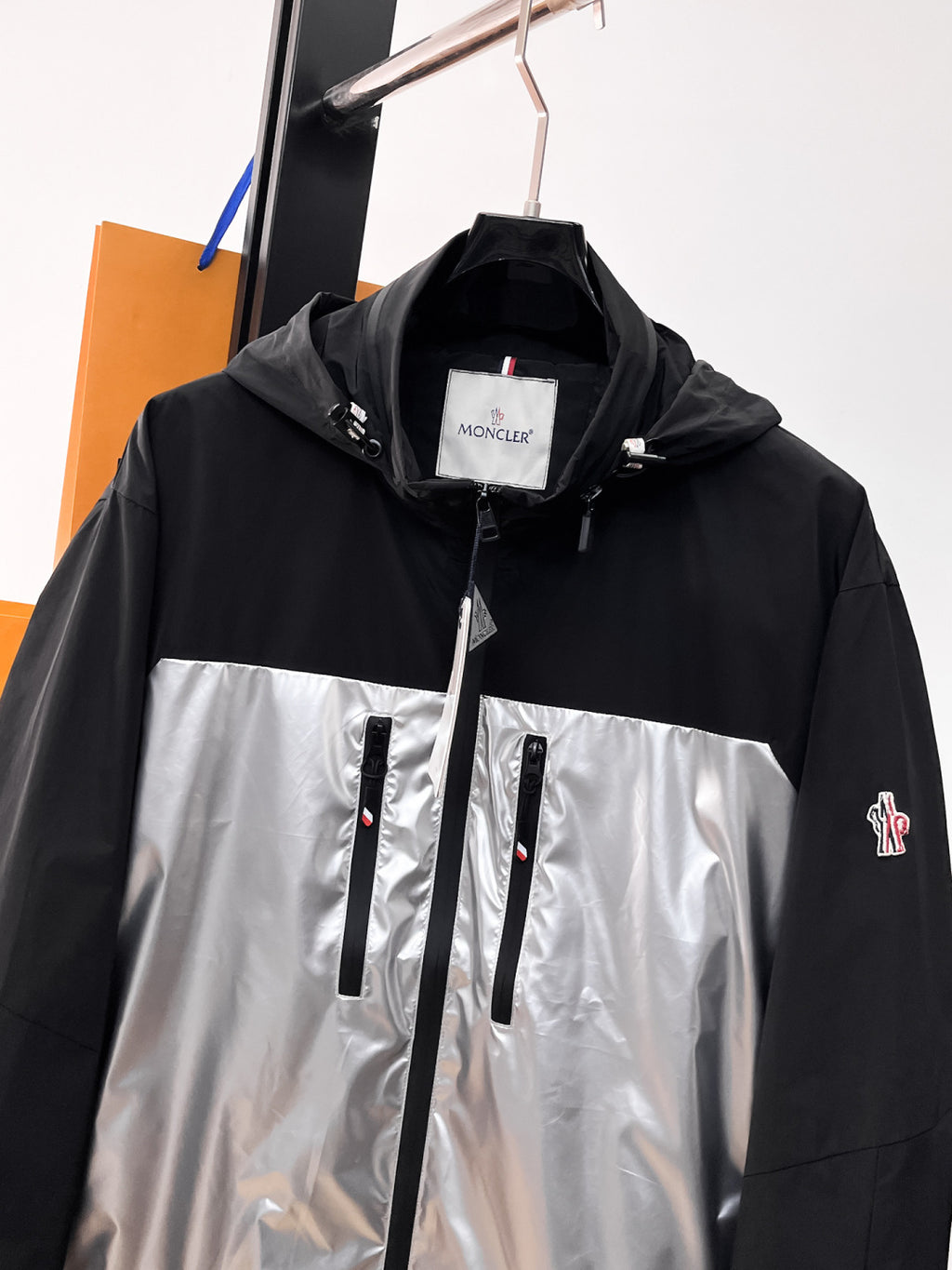 Moncler long two-tone jacket with hood, full-length zipper, and logo badge