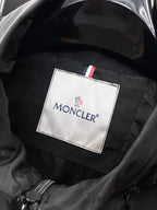 Moncler logo patch on jacket lining with dark quilted texture