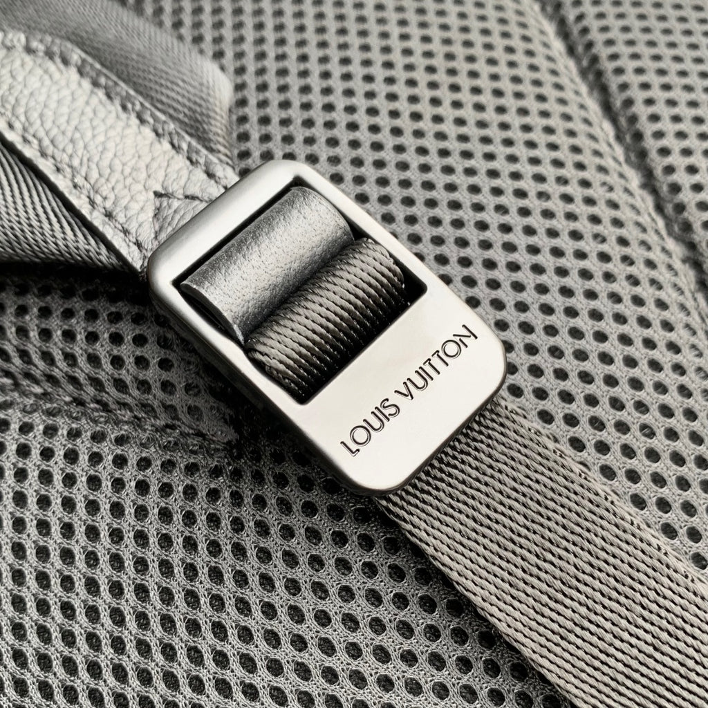 Men's Louis Vuitton leather backpack close-up of metal strap slider with logo