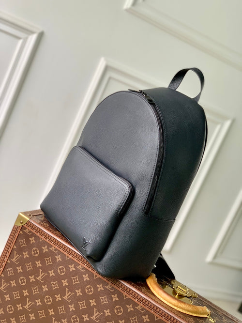 Men's Louis Vuitton leather backpack in dark gray, angled side view with front pocket