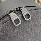 Men's Louis Vuitton leather backpack close-up of zip pulls with logo tags