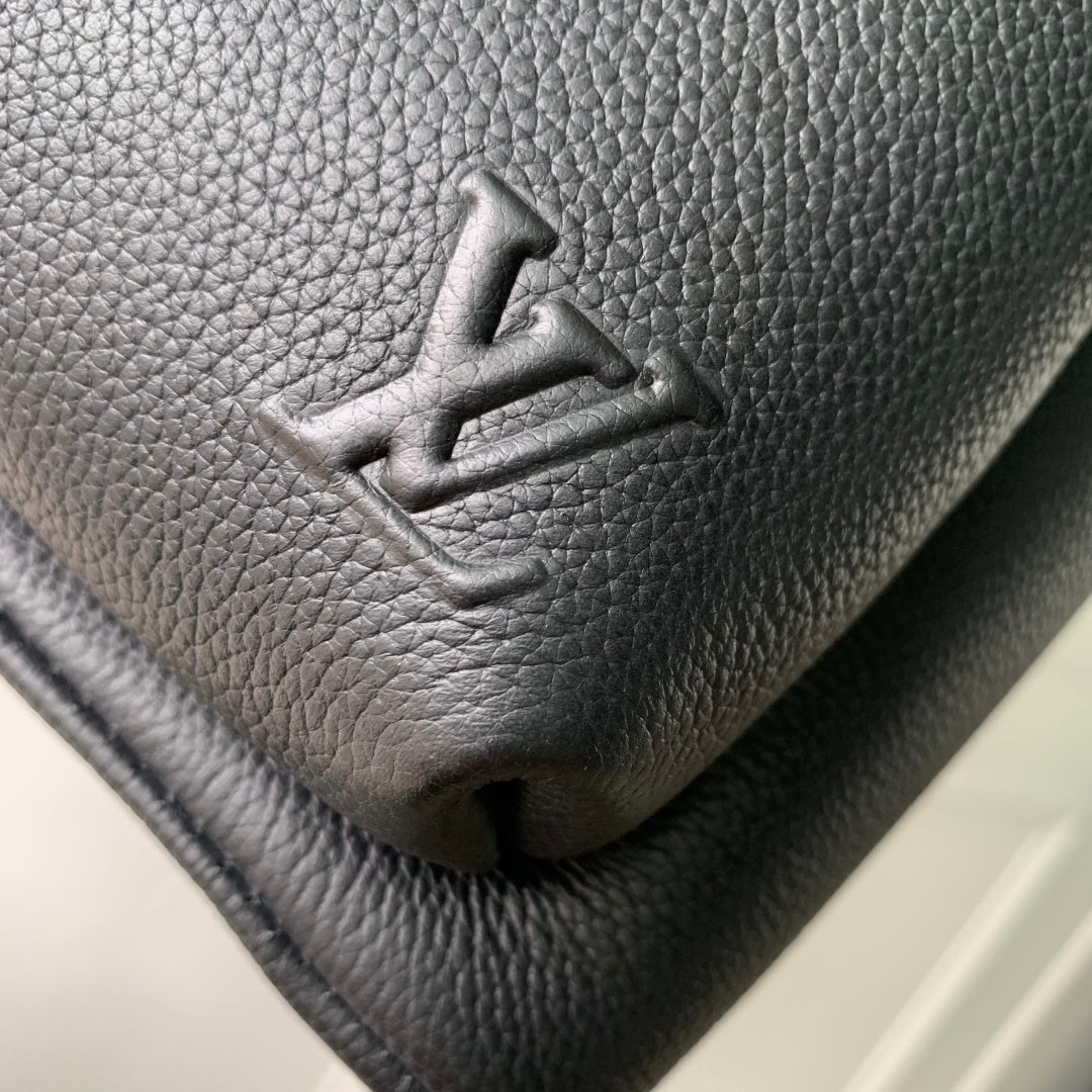 Men's Louis Vuitton leather backpack close-up of embossed logo on textured surface
