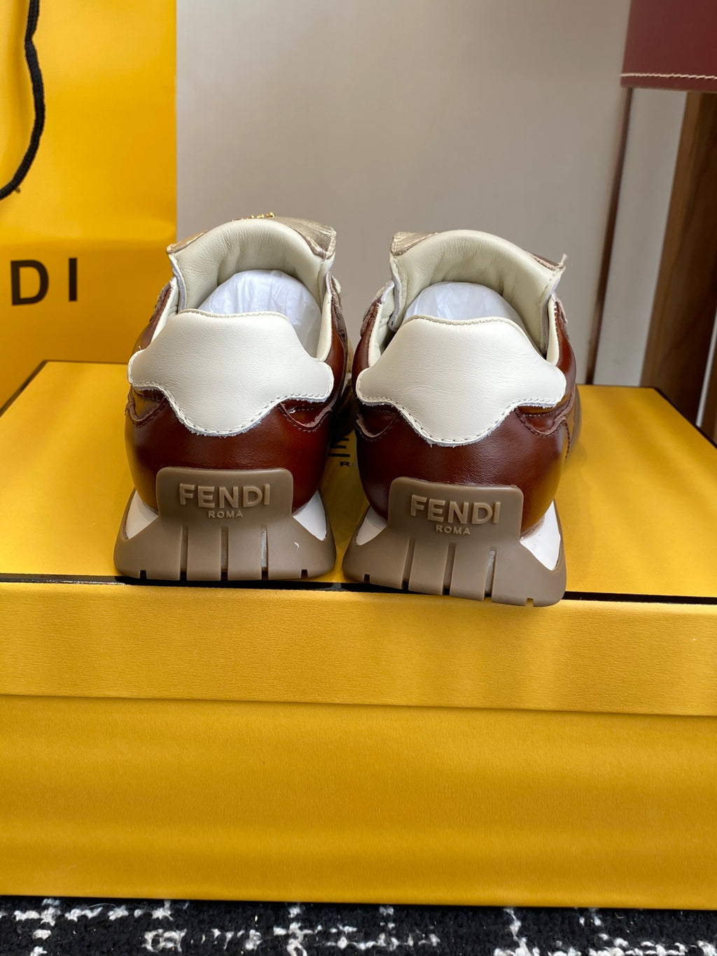 Fendi sneakers back view: brown heels, metallic silver uppers, rubber sole.
