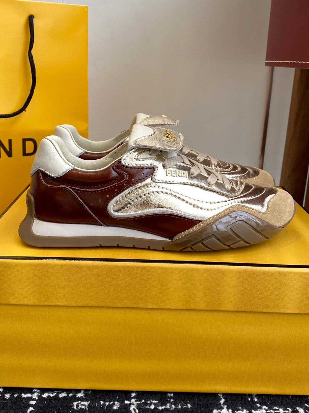 Fendi sneakers: metallic silver uppers, brown trim, white laces, treaded sole.