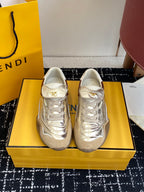 Fendi unisex sneakers, metallic silver with white laces, set on a yellow box