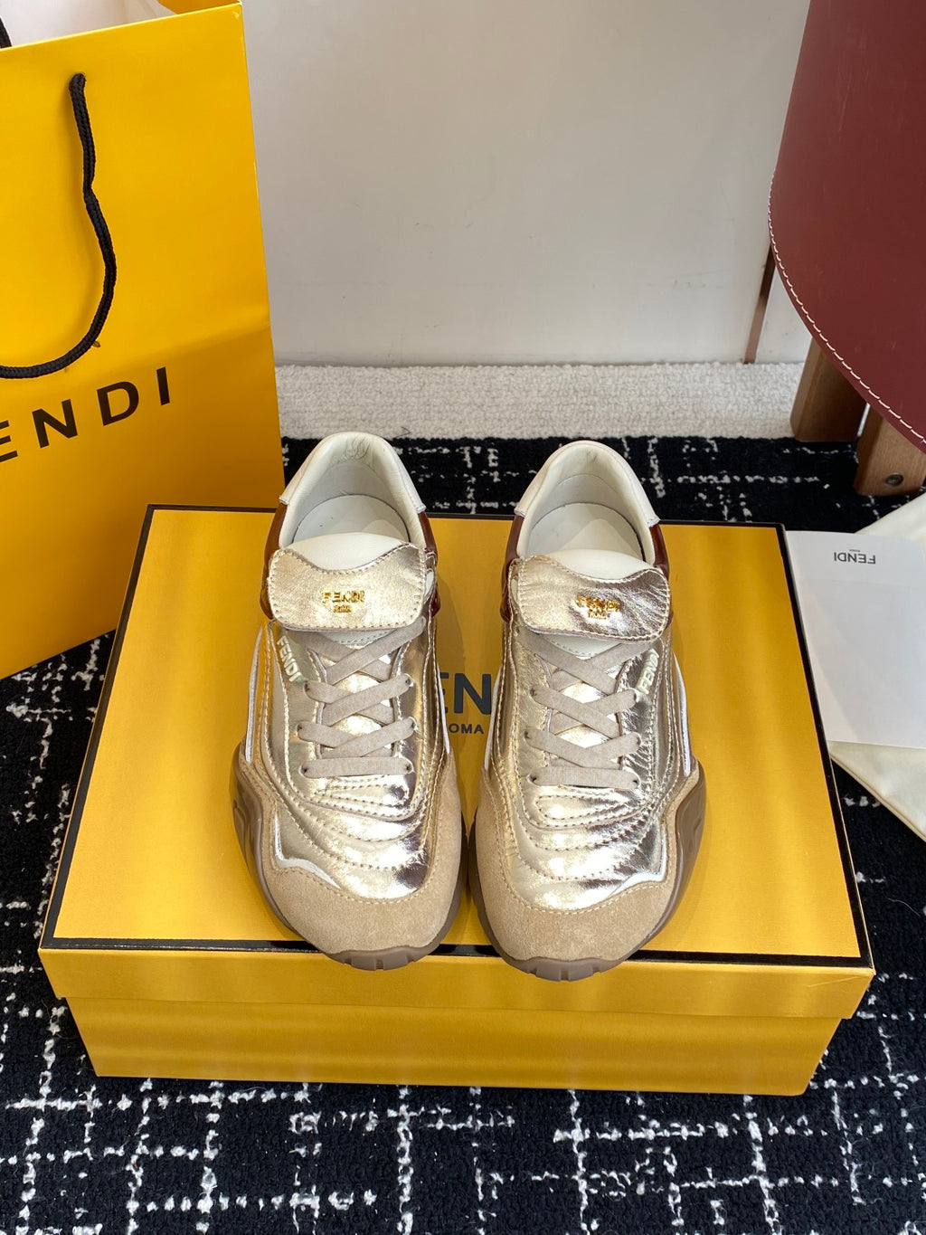 Fendi unisex sneakers: metallic silver, brown side panels, white laces.