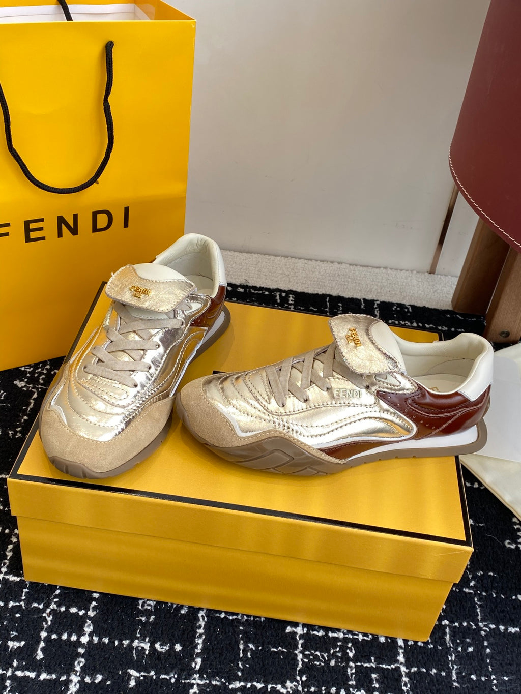 Fendi unisex sneakers, metallic silver with brown accents, shown from a side angle