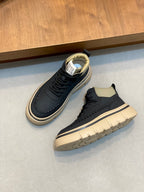 Pair of navy low-top sneakers with cream soles, black laces, and contrast piping