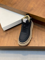 Navy low-top sneaker with cream sole and black lace-up, heel branding detail