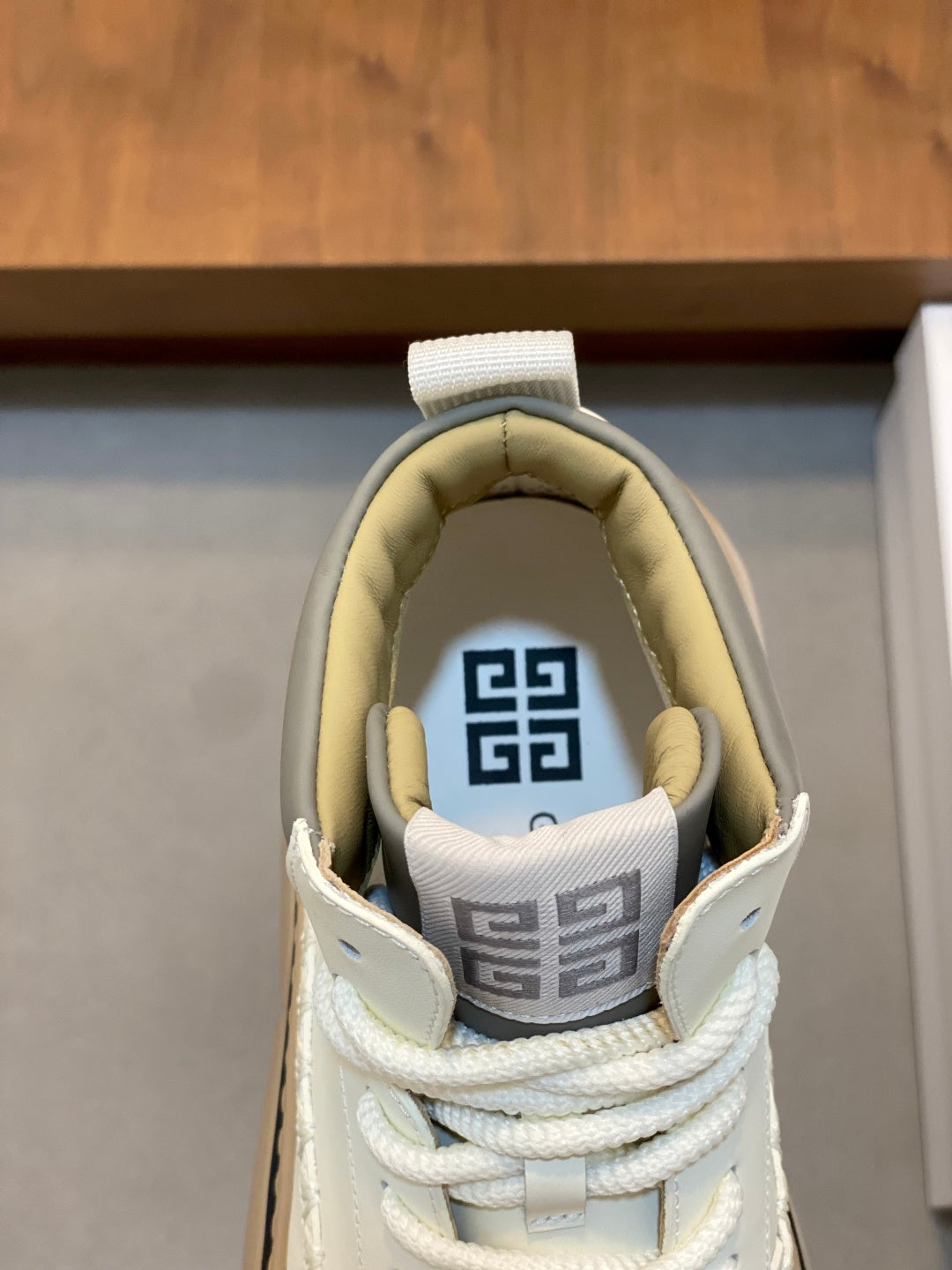 Sneaker tongue lining with patterned logo print and white laces.