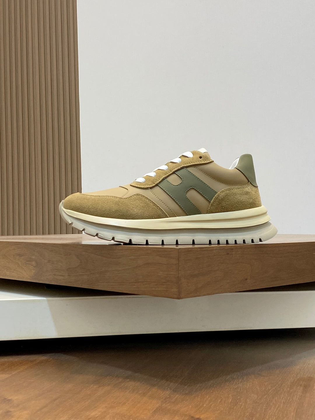 Beige suede sneakers with green side logo panel and white rubber sole