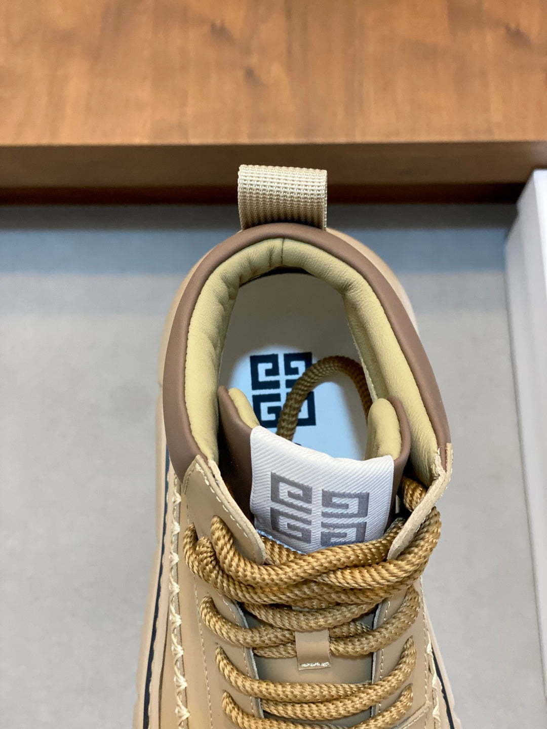 Givenchy luxury shoes, close-up of cream lace-up tongue with blue-and-white logo patch