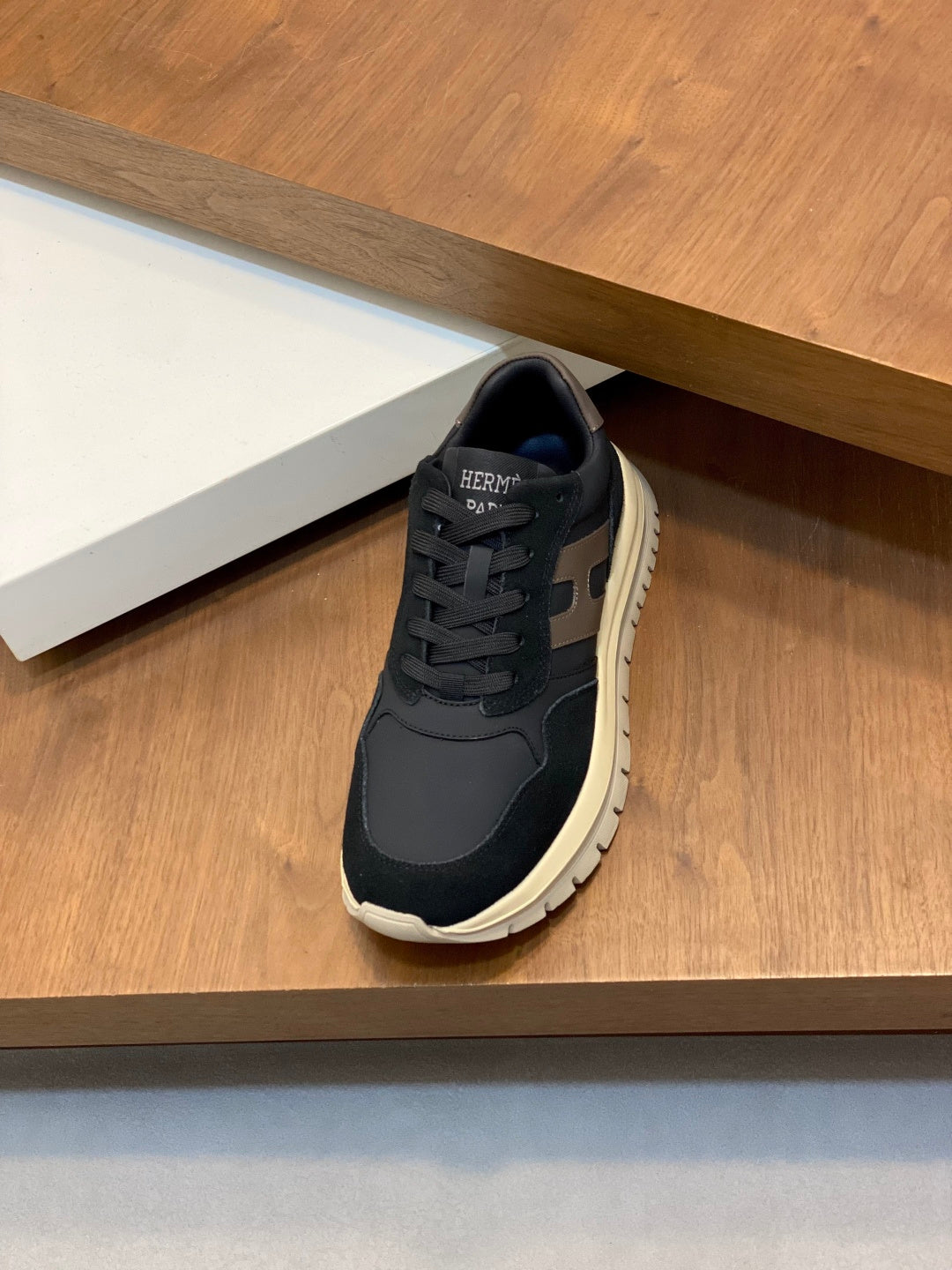 Black lace-up sneakers with beige-gray panels and thick cream sole