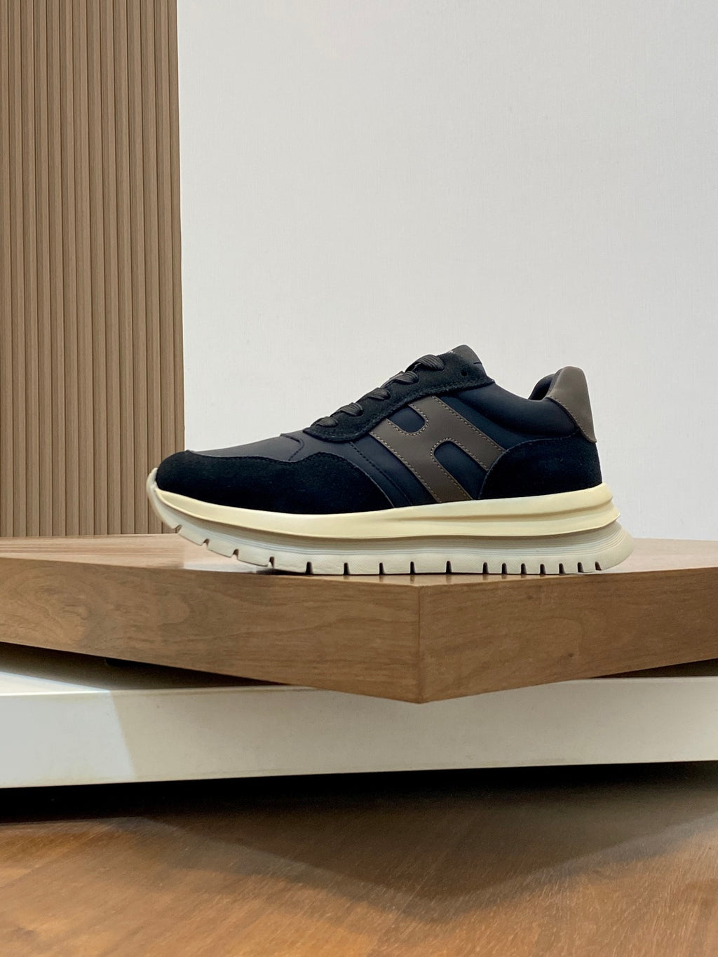Navy lace-up sneakers with blue side stripes and cream rubber sole