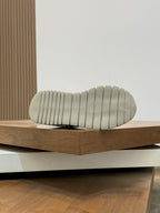 Shoe sole view with textured tread and ribbed grip pattern on light outsole