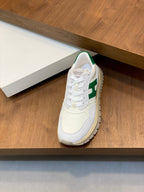 White lace-up sneaker with green collar accents and cushioned tongue, side view