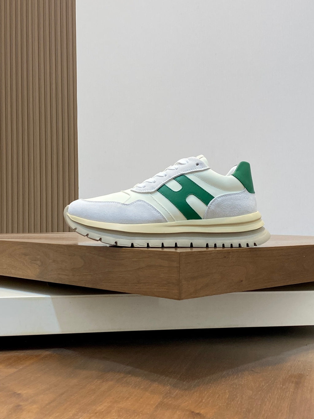 White lace-up sneakers with green stripe detail and light blue side panel