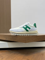 White lace-up sneakers with green stripe detail and light blue side panel