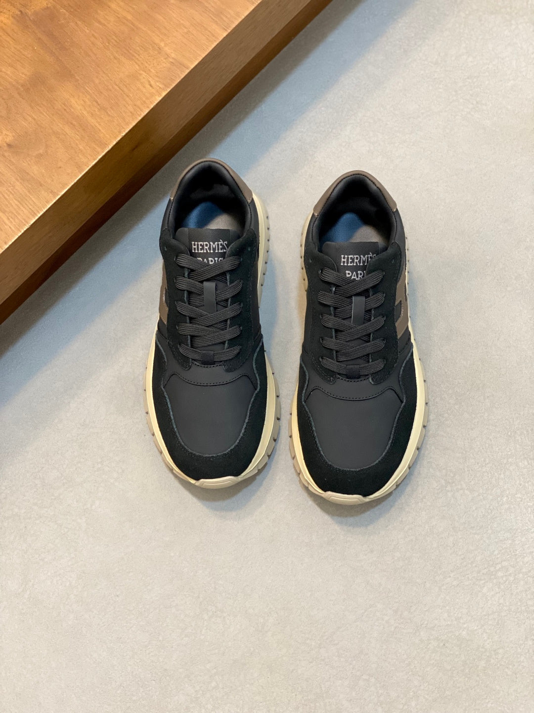 Dark navy lace-up sneakers, cream sole, logo on tongue