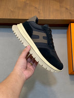 Black lace-up low-top sneakers with beige panels and chunky sole