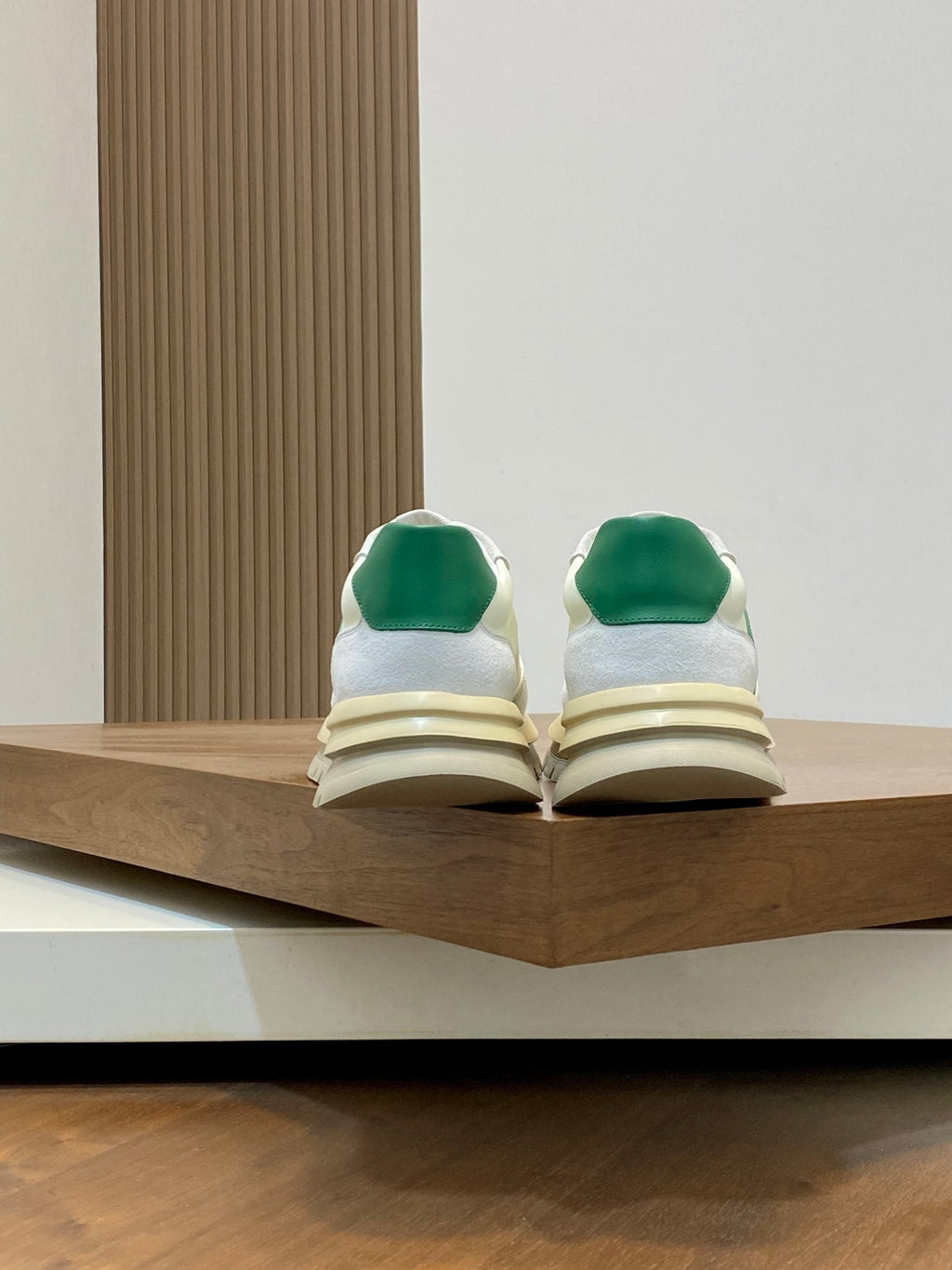 White sneakers with green heel tabs and layered midsole, back view pair