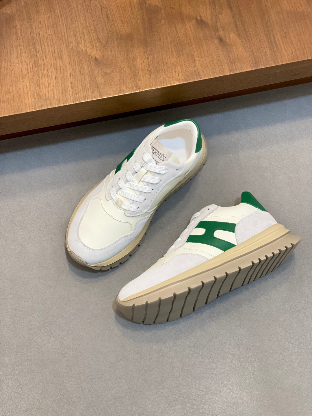 Pair of white sneakers with green side accents, lace-up front and rubber sole