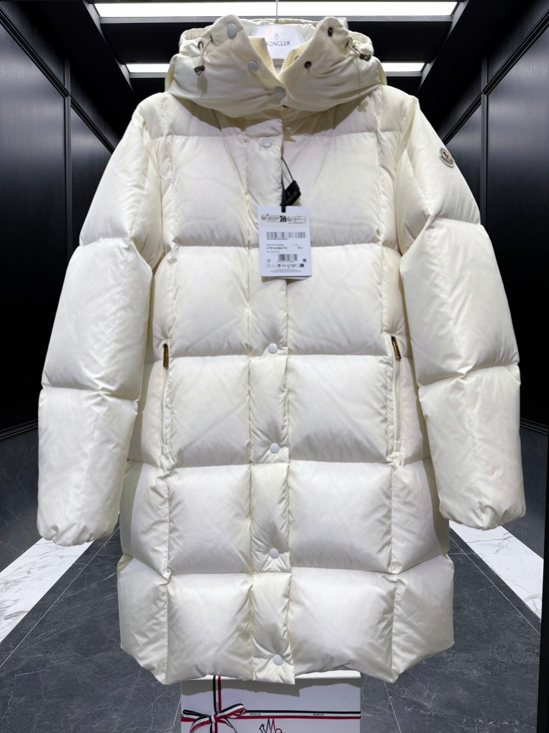 Light cream long puffer coat with hood, diamond quilting, buttoned front, elastic cuffs.