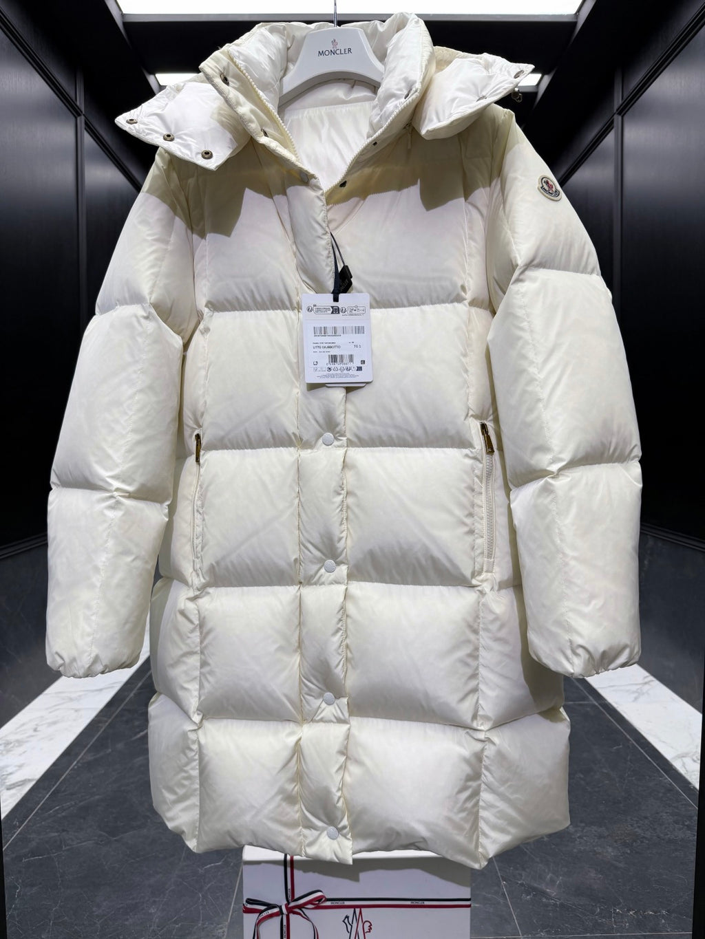 Light cream long puffer coat with hood, diamond quilting, front button placket, cuffs.