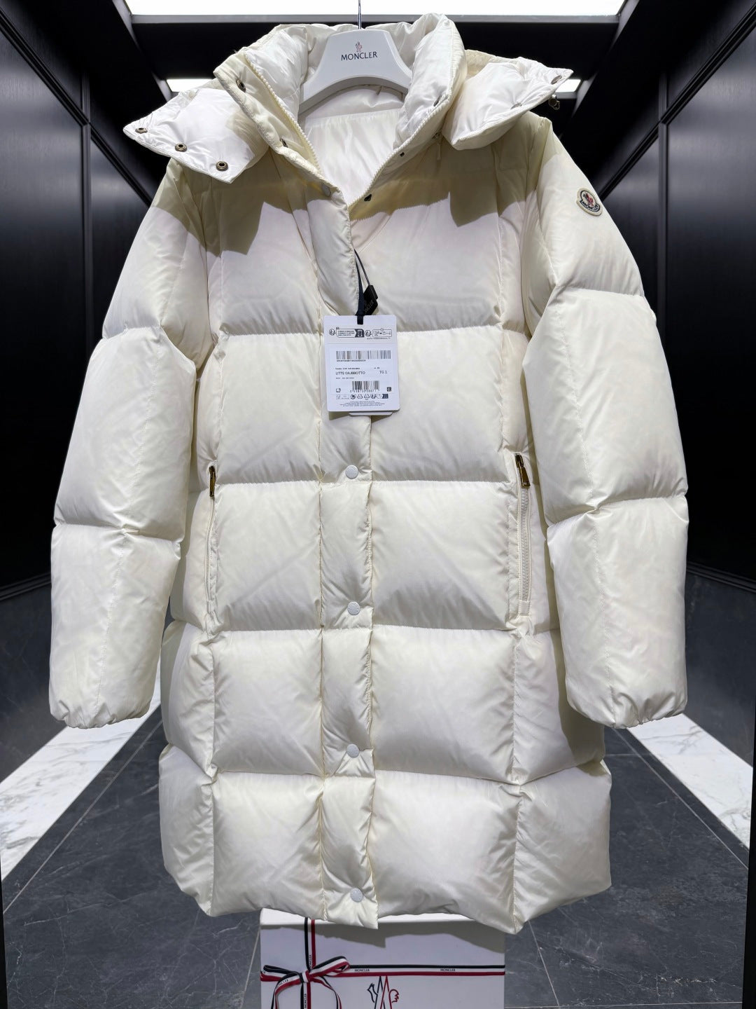 Light cream long puffer coat with hood, diamond quilting, front button placket, cuffs.