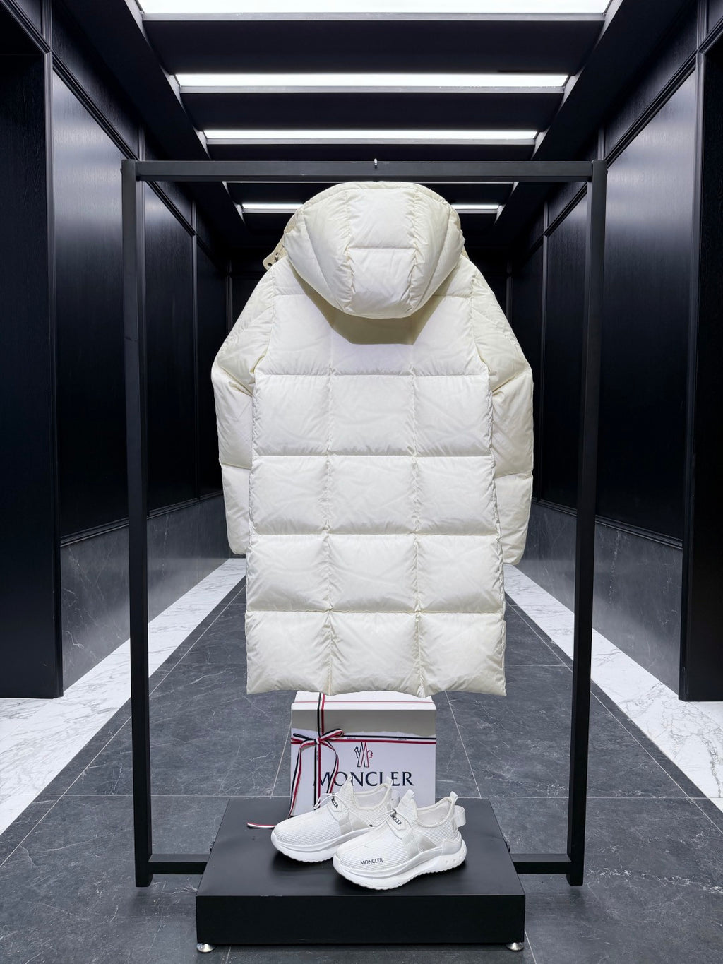 Back of long quilted puffer coat with hood, light cream, diamond stitching.