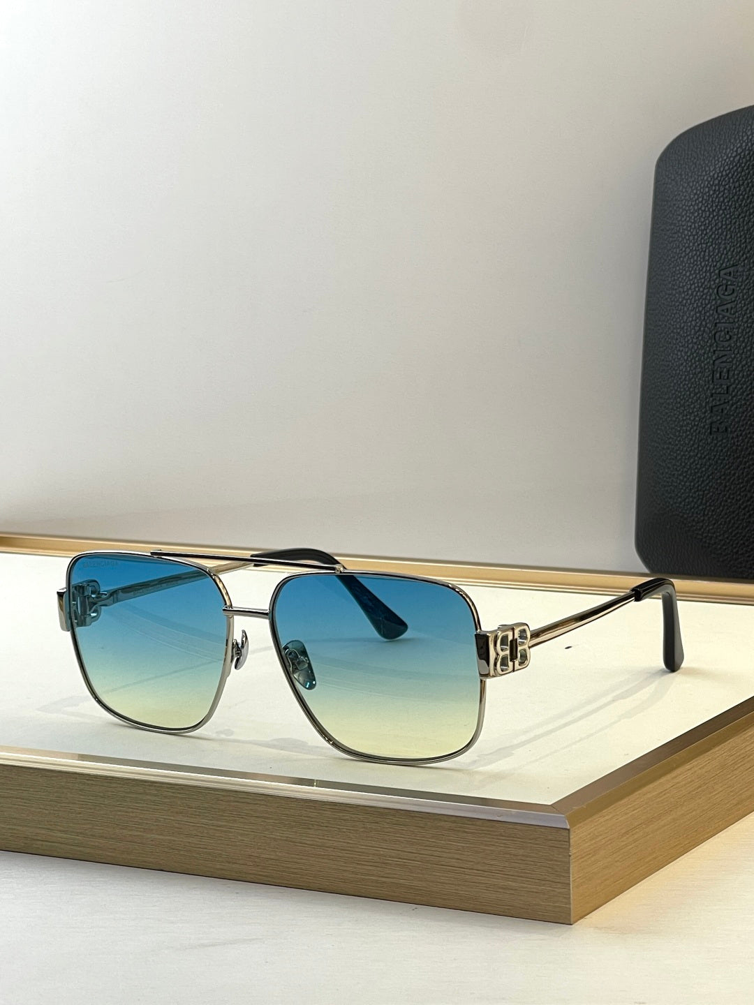 Square gold sunglasses with blue-tinted lenses and black temple tips