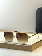 Square gold sunglasses with brown-tinted lenses and black temple tips