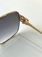 Gold sunglasses close-up of temple hinge and dark lens frame