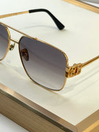 Gold sunglasses close-up with dark lenses and embossed logo detail