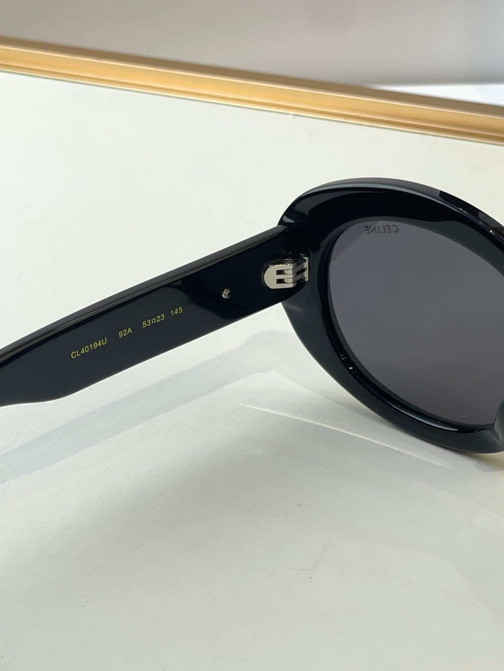 Black sunglasses close-up showing temple markings and dark lenses