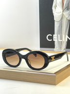 Black round sunglasses with gold temple logo and dark-tinted lenses