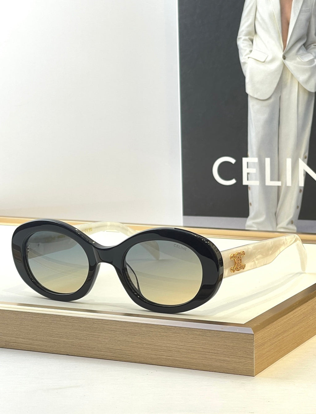 Black sunglasses with gold temple accents and light-tinted lenses